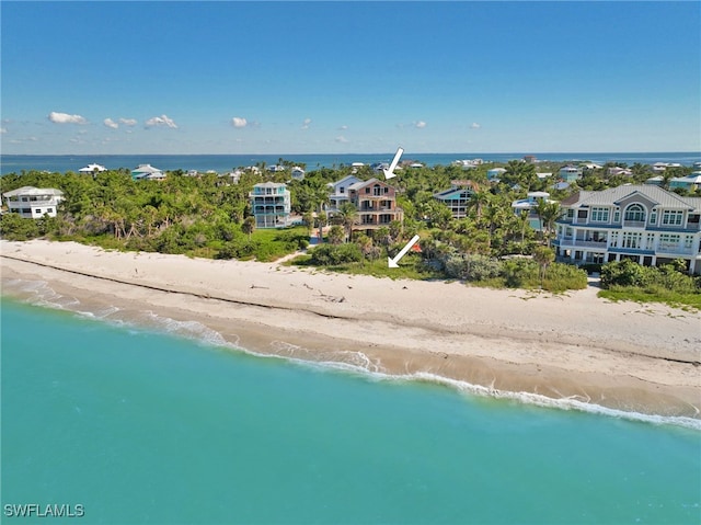 birds eye view of property with a water view and a beach view