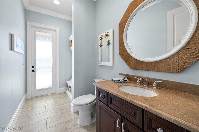 bathroom with vanity, toilet, and ornamental molding