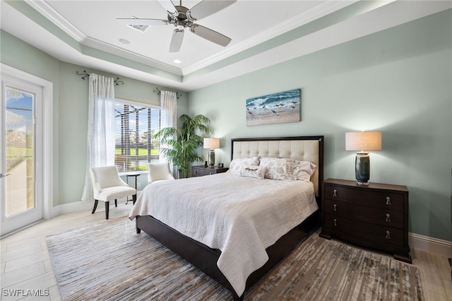 bedroom with ceiling fan, a raised ceiling, wood-type flooring, access to outside, and ornamental molding