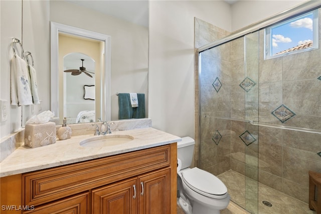 bathroom featuring ceiling fan, vanity, an enclosed shower, and toilet