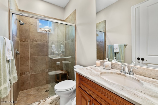 bathroom with an enclosed shower, vanity, and toilet