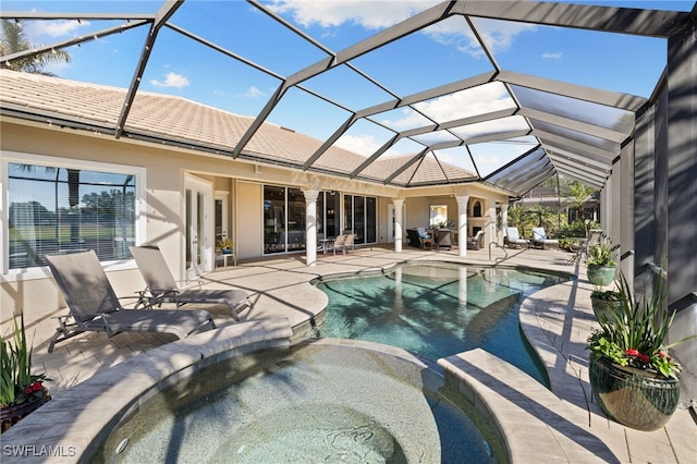 view of swimming pool featuring a lanai, a patio area, and an in ground hot tub