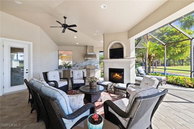 view of patio / terrace with an outdoor living space with a fireplace and ceiling fan