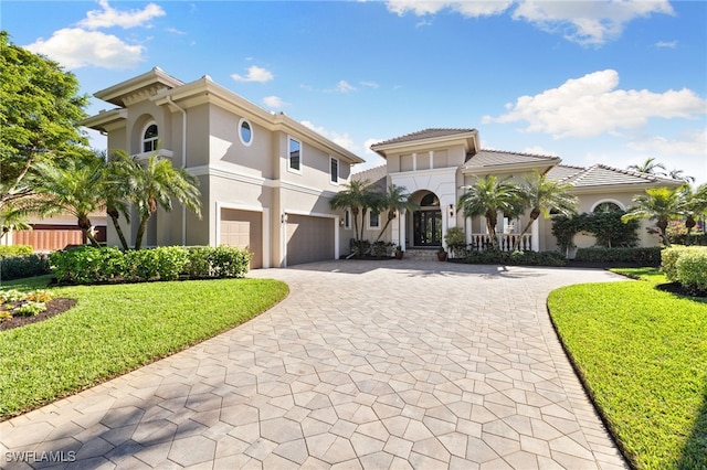 mediterranean / spanish home featuring a garage and a front lawn