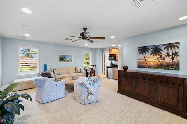 carpeted living room with ceiling fan