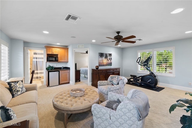 carpeted living room with ceiling fan