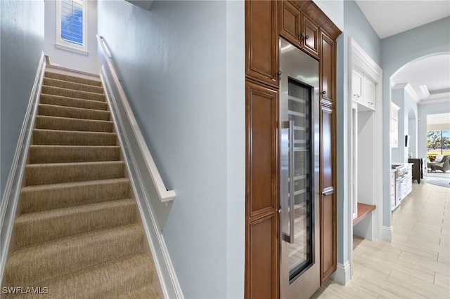 stairway with wine cooler and ornamental molding