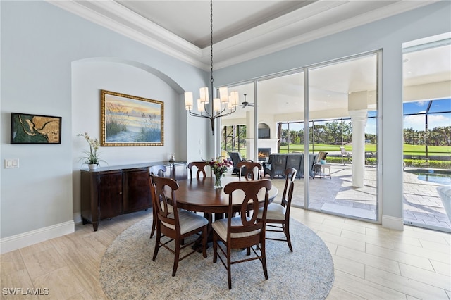 dining space featuring ornamental molding, a tray ceiling, plenty of natural light, and a notable chandelier