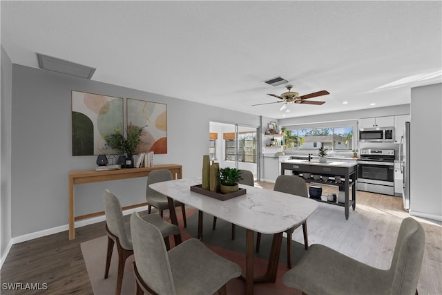 dining space with hardwood / wood-style flooring and ceiling fan