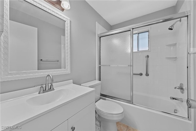 full bathroom featuring tile patterned flooring, vanity, toilet, and bath / shower combo with glass door