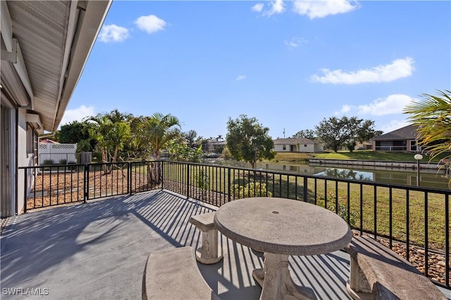 view of patio with a water view and a balcony