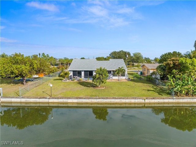 back of house with a yard and a water view