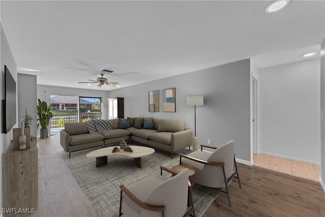 living room featuring wood-type flooring and ceiling fan