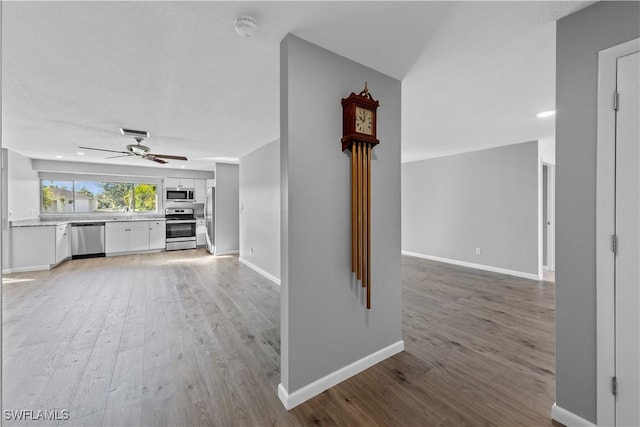 unfurnished living room with hardwood / wood-style flooring and ceiling fan