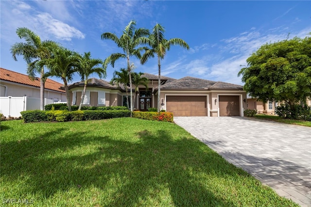 view of front of home with a garage and a front lawn