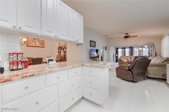 kitchen with white cabinetry, ceiling fan, light stone counters, kitchen peninsula, and light tile patterned floors