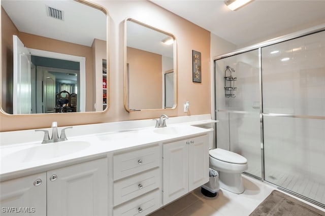 bathroom featuring tile patterned flooring, vanity, toilet, and walk in shower