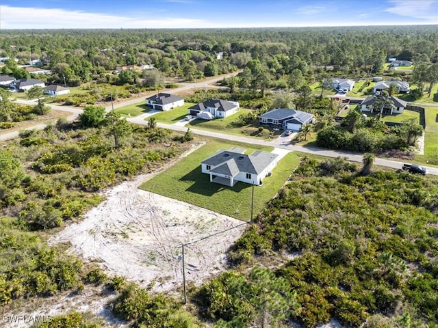 drone / aerial view featuring a residential view and a forest view