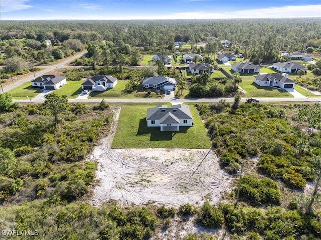 birds eye view of property with a forest view and a residential view