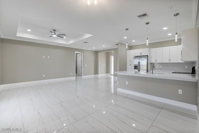 kitchen featuring stainless steel refrigerator with ice dispenser, visible vents, light countertops, open floor plan, and a sink