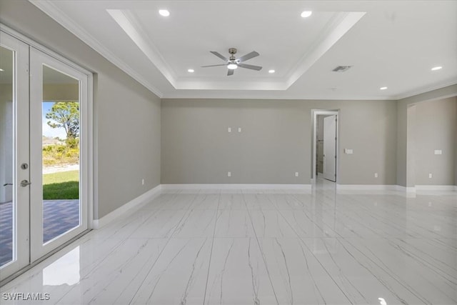 unfurnished room with baseboards, visible vents, a tray ceiling, and ornamental molding