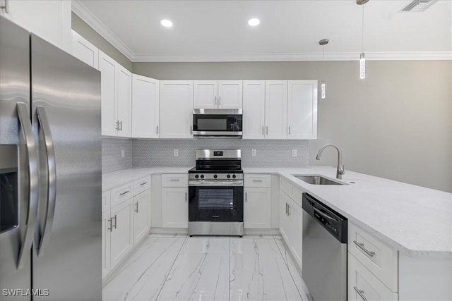 kitchen with a peninsula, a sink, white cabinets, hanging light fixtures, and appliances with stainless steel finishes