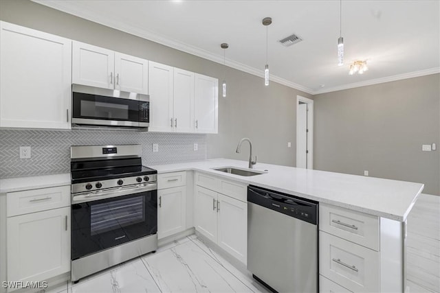 kitchen with stainless steel appliances, hanging light fixtures, white cabinets, a sink, and a peninsula