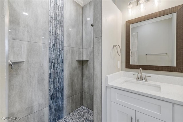 full bath with a tile shower and vanity