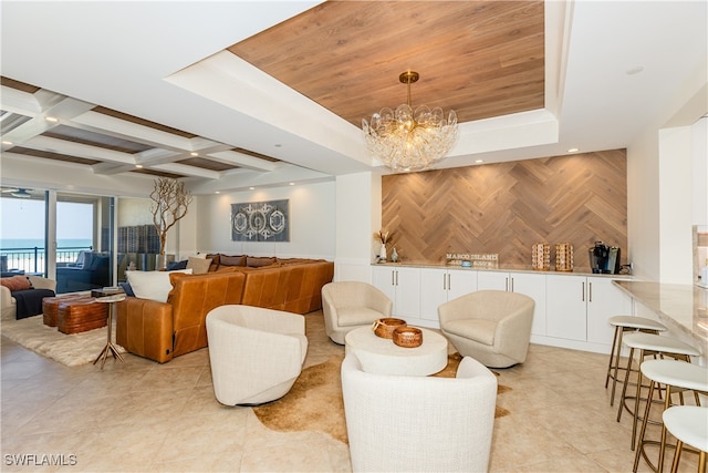 living room with a notable chandelier, light tile patterned floors, wooden walls, beamed ceiling, and coffered ceiling