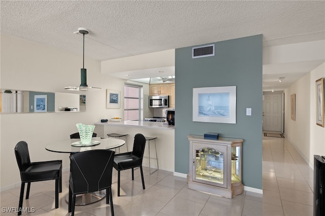 dining area with light tile patterned floors and a textured ceiling