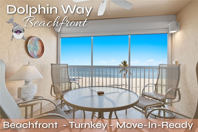 interior space featuring ceiling fan, a water view, and a view of the beach