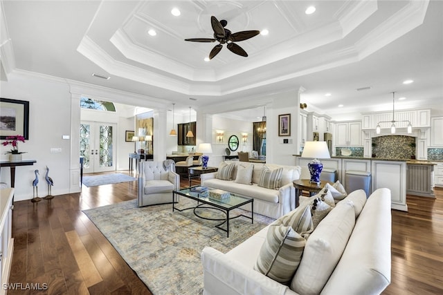 living room with a raised ceiling, ornamental molding, dark hardwood / wood-style floors, and french doors