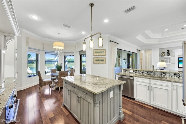 kitchen with dark wood-type flooring, sink, light stone counters, decorative light fixtures, and stainless steel appliances