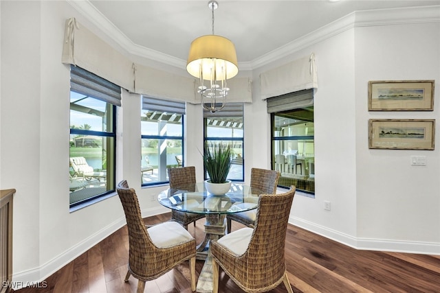 dining area with crown molding, dark hardwood / wood-style flooring, and an inviting chandelier