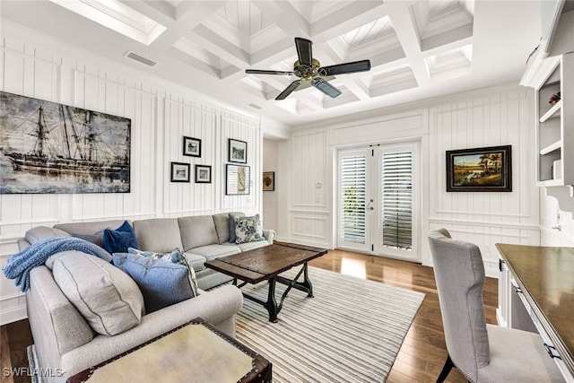 living room with beamed ceiling, wood-type flooring, coffered ceiling, and ornamental molding