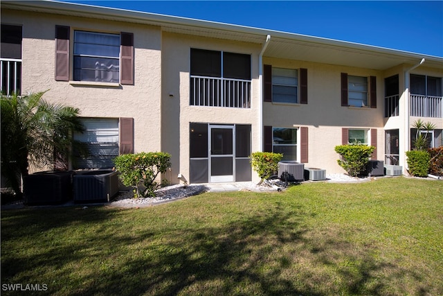 rear view of property with a yard and cooling unit