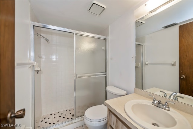 bathroom featuring tile patterned flooring, vanity, toilet, and an enclosed shower