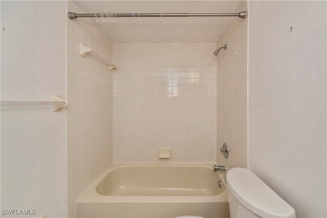 bathroom with tiled shower / bath combo and toilet