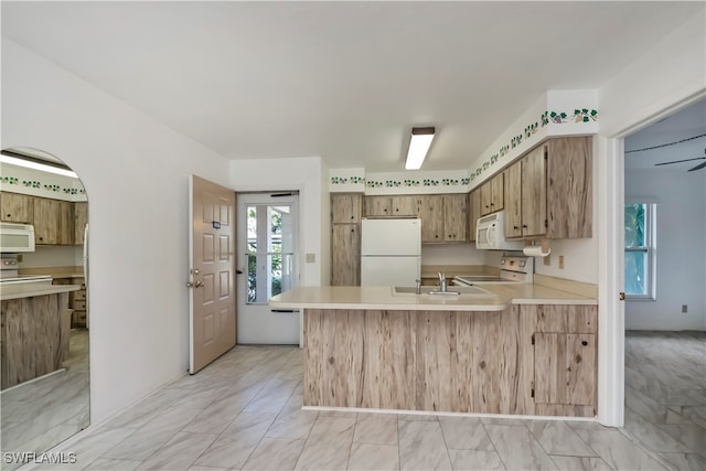 kitchen with kitchen peninsula, white appliances, and sink