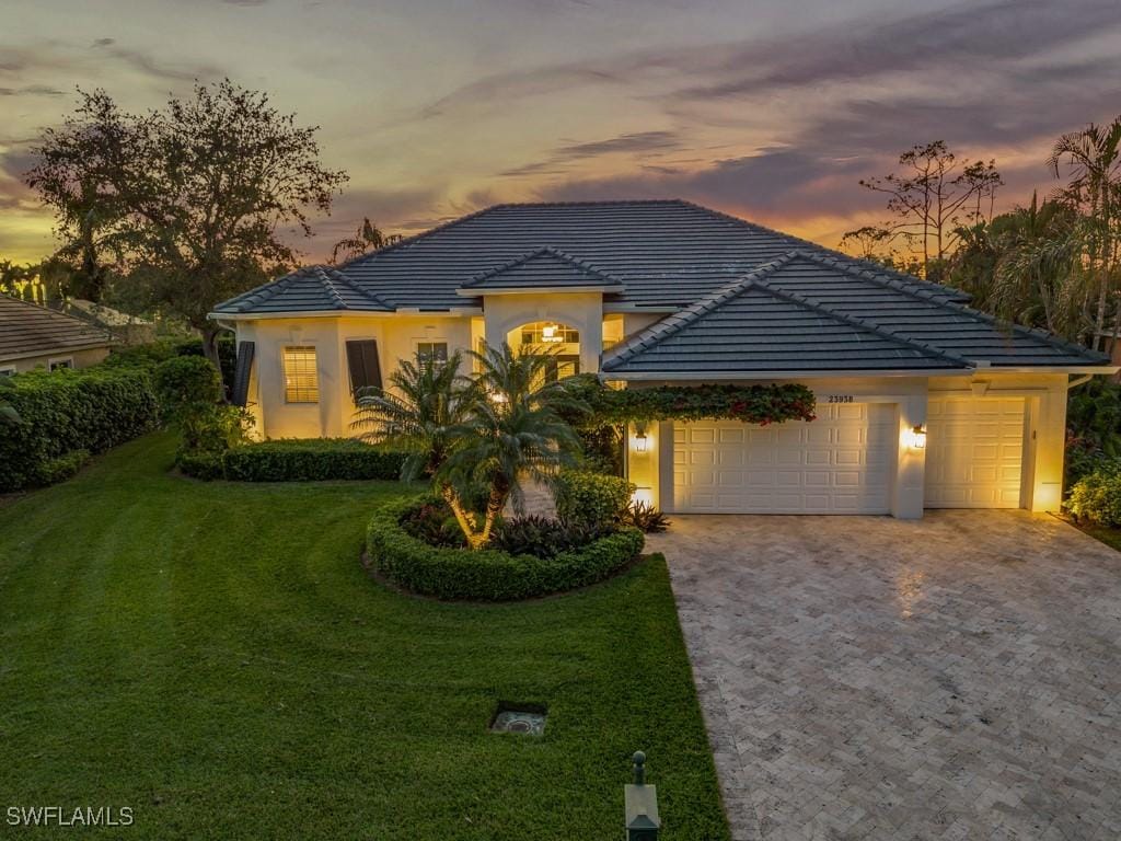 view of front of property with a yard and a garage