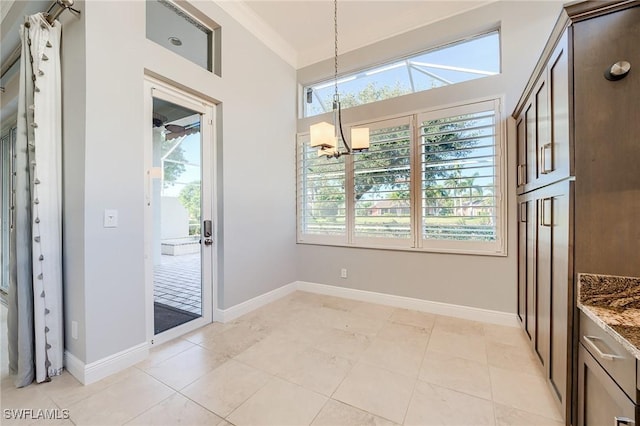 dining space featuring crown molding, light tile patterned floors, and a chandelier