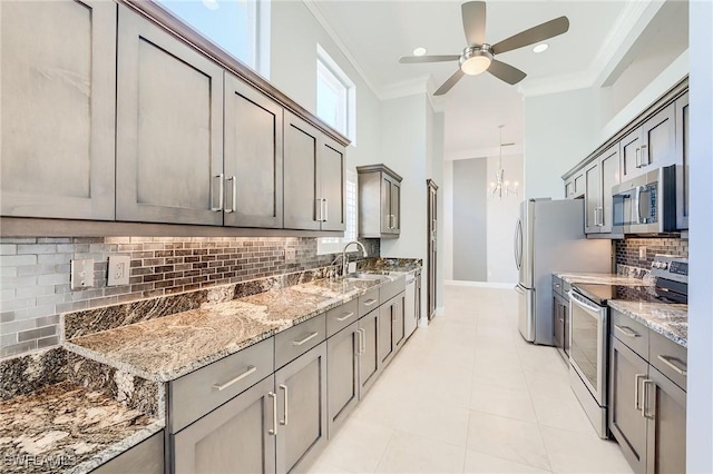 kitchen with light stone countertops, sink, tasteful backsplash, appliances with stainless steel finishes, and ornamental molding