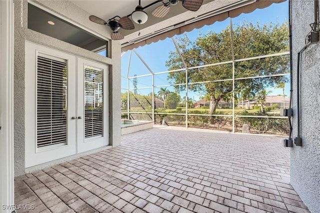 view of patio / terrace featuring ceiling fan, glass enclosure, and french doors