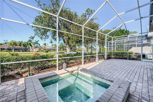 view of pool with a lanai and a jacuzzi