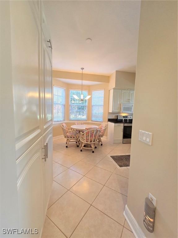 dining space with light tile patterned floors and a notable chandelier