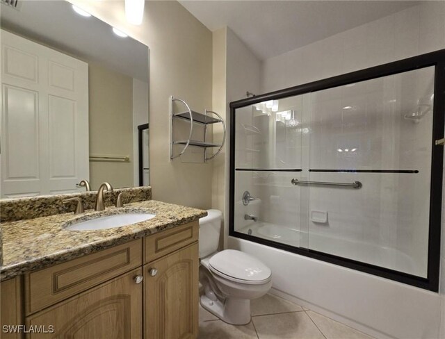 full bathroom featuring tile patterned flooring, toilet, combined bath / shower with glass door, and vanity