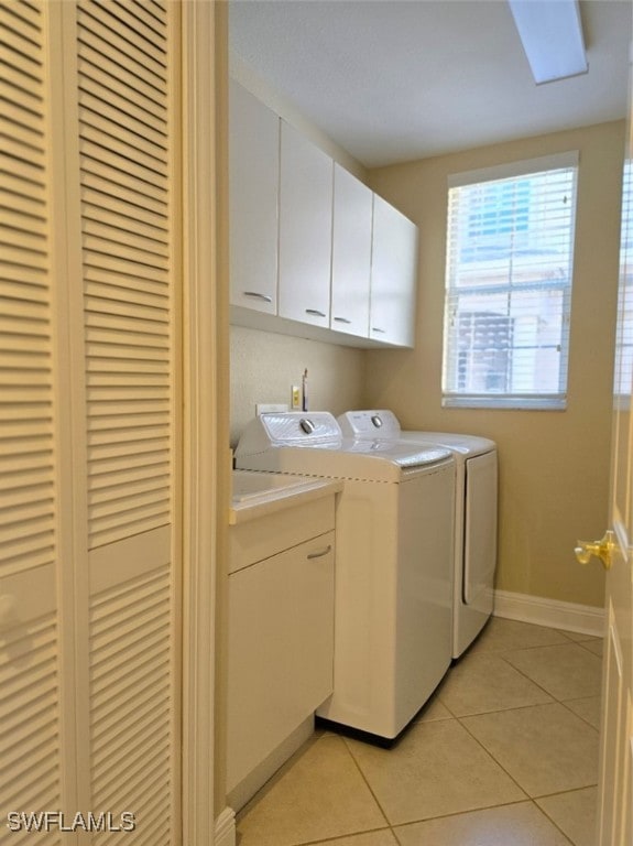 washroom featuring cabinets, independent washer and dryer, and light tile patterned floors