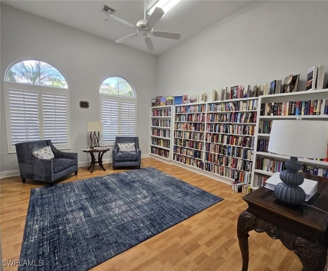 living area featuring wood-type flooring and ceiling fan