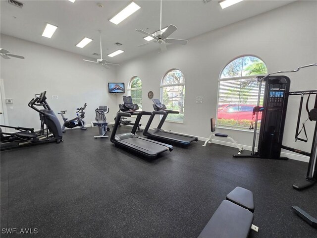 workout area with a towering ceiling and ceiling fan