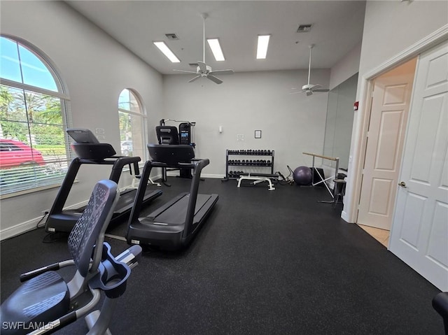 workout area featuring visible vents, baseboards, a skylight, and a ceiling fan